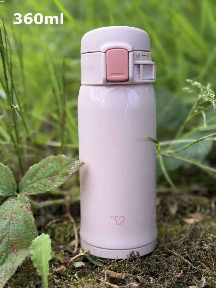 Zojirushi SM-SR60 Pink Travel Mug β 360 ml stainless steel insulated bottle with flip-top lid, BPA-free, outdoors photo on grass.